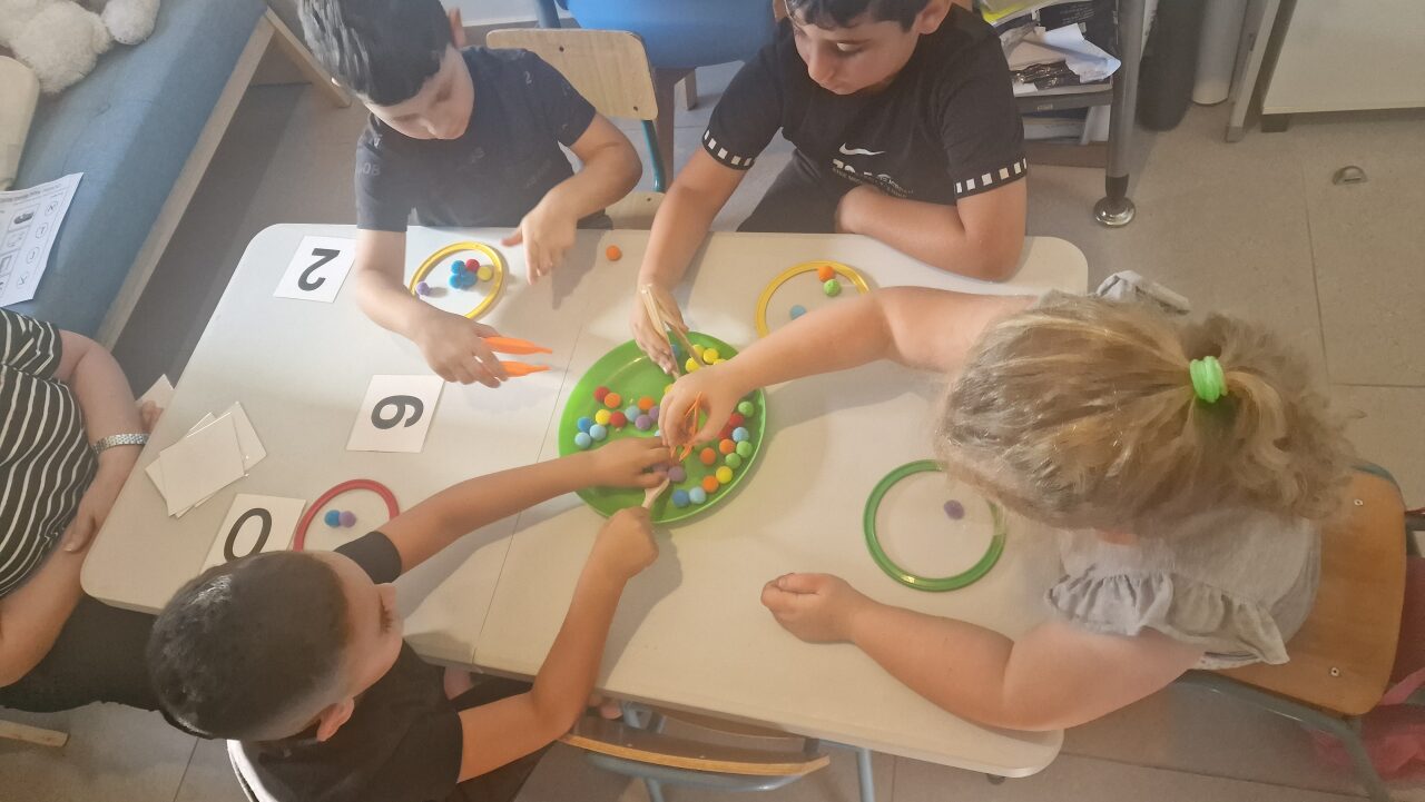 ילדים לומדים יחד סביב שולחן בקבוצת למידה במרכז רגב בראשון לציון